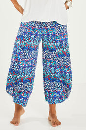 Model Noli wearing size 14 of the Good Vibes Balloon Hem Pants in colour Aztec (Blue), from the front, cropped image