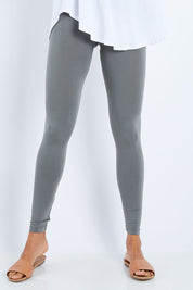 Model Amanda wearing size 10 of the Softly Swinging Bamboo Leggings in colour Fern (Green), from the front, cropped image