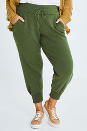 Model Palatina wearing size XL of the Snuggle Up Cotton Cashmere Lounge Pants in colour Forest (Green), from the front, cropped image