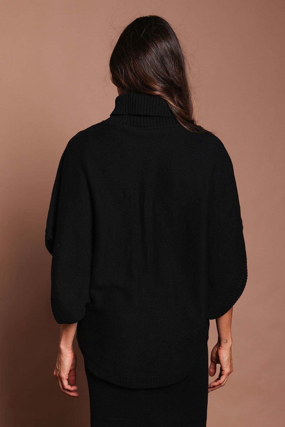 Model Amanda wearing size S of the Knit Pick Throw Sweater in colour Black (Black), from the back