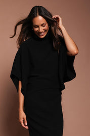 Model Amanda wearing size S of the Knit Pick Throw Sweater in colour Black (Black), from the front, showing the whole outfit