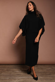 Model Amanda wearing size S of the Knit Pick Throw Sweater in colour Black (Black), from the front, showing the whole outfit