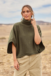 Model Tegan wearing size S of the Knit Pick Throw Sweater in colour Khaki (Green), from the front, showing the whole outfit