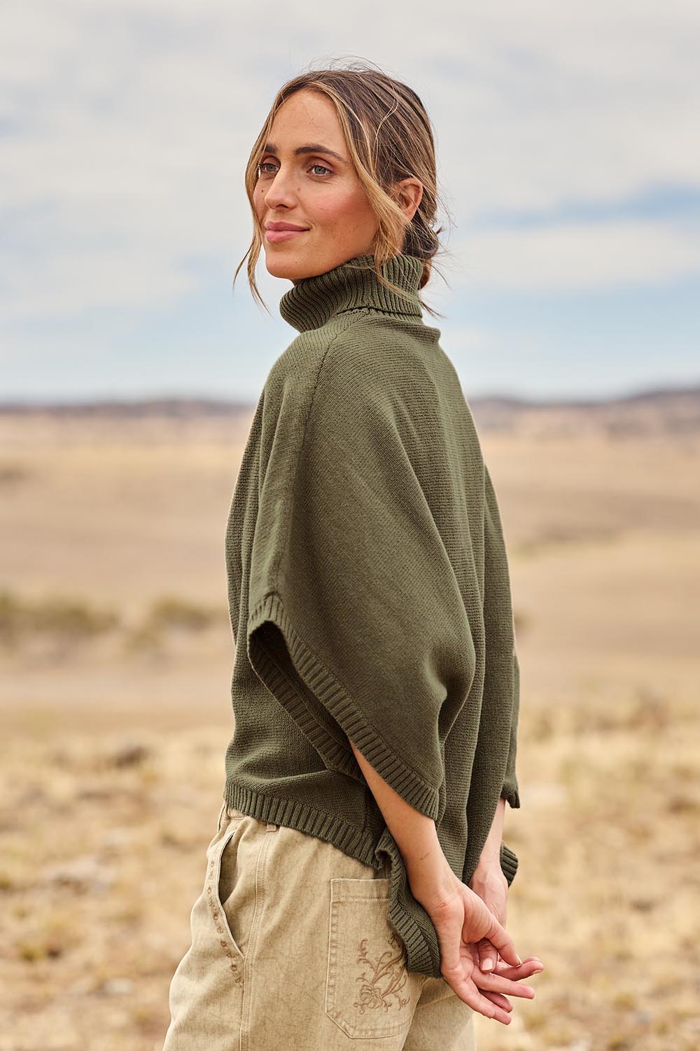 Model Tegan wearing size S of the Knit Pick Throw Sweater in colour Khaki (Green), from the front, showing the whole outfit