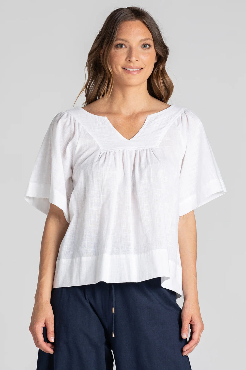 A model wearing the Freya Top in colour White (White), from the front, cropped image