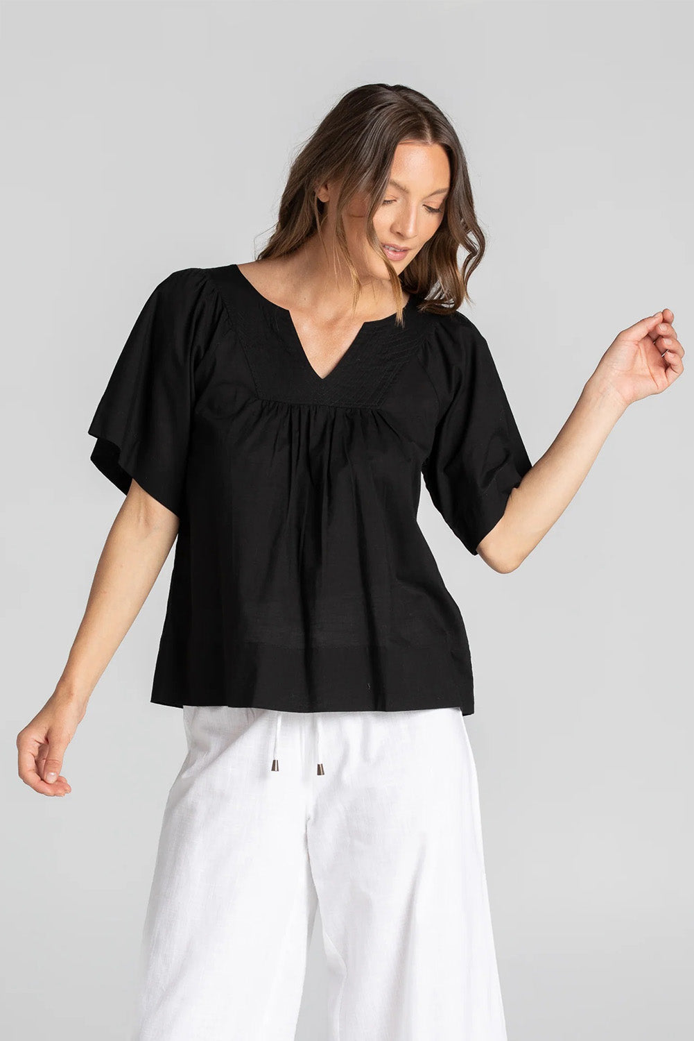 A model wearing the Freya Top in colour Black (Black), from the front, showing the whole outfit