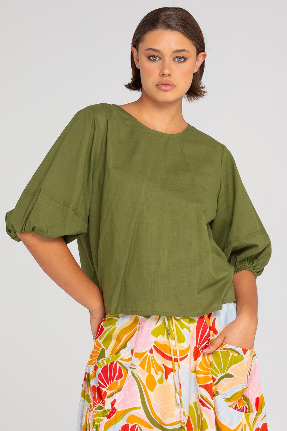 A model wearing the Ava Cotton Top in colour Khaki (Green), from the front, cropped image