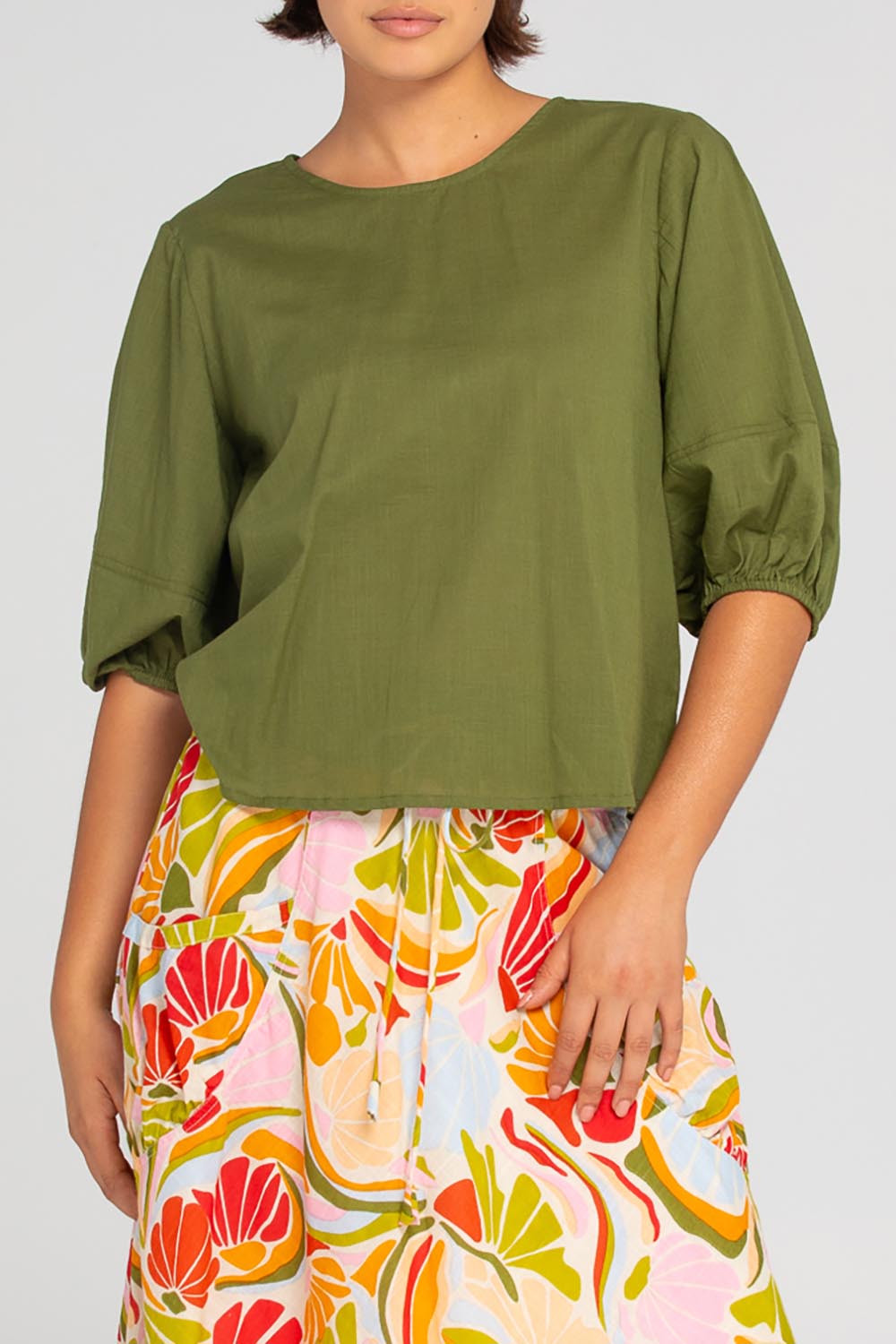 A model wearing the Ava Cotton Top in colour Khaki (Green), from the front, cropped image