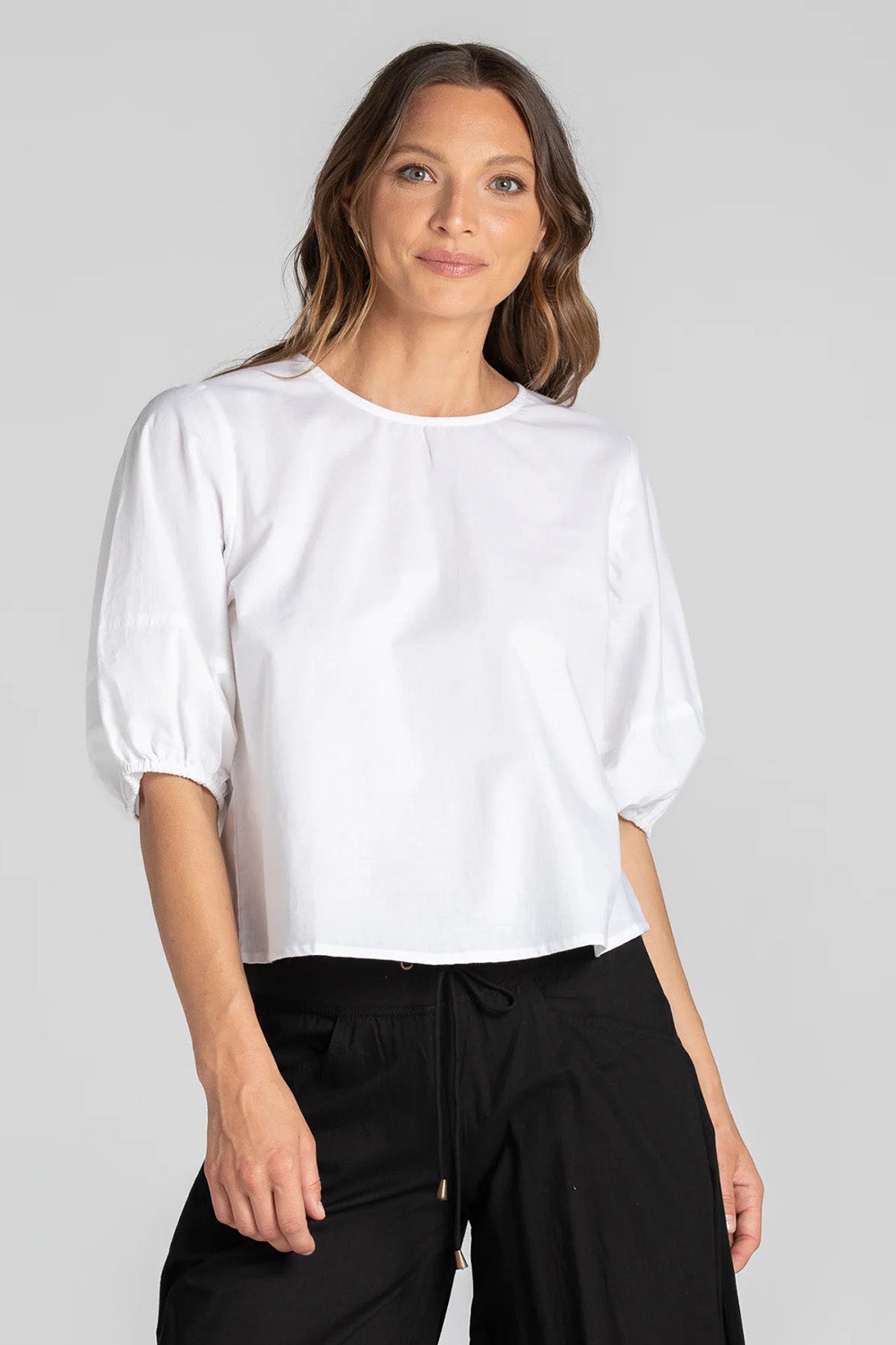 A model wearing the Ava Top in colour White (White), from the front, showing the whole outfit