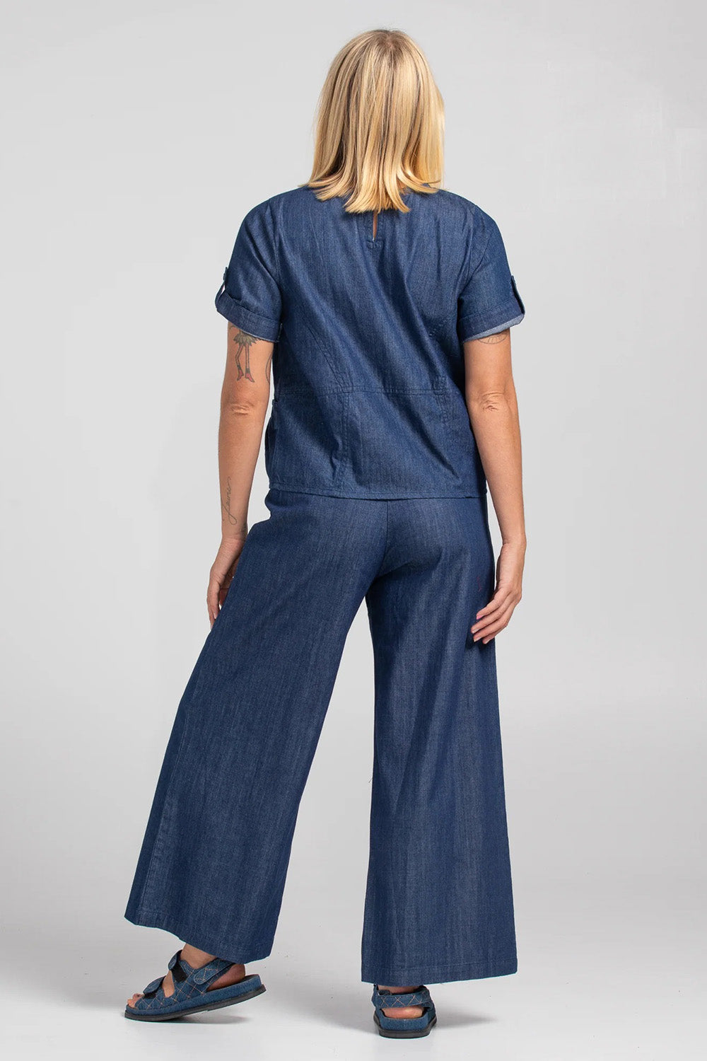 A model wearing the Guru Denim Top in colour Darkdenim (Blue), from the back
