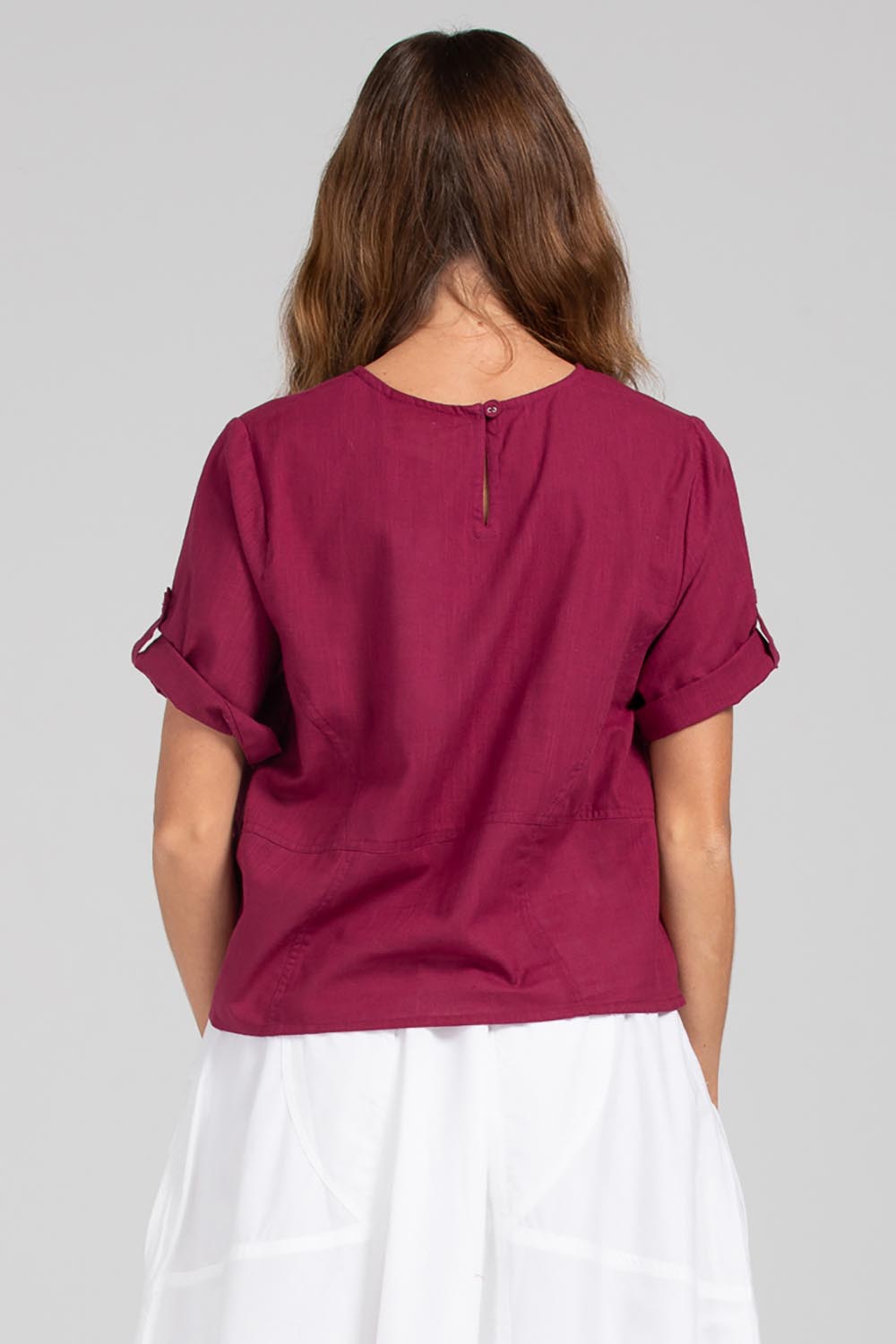A model wearing the Guru Cotton Top in colour Magenta (Purple), from the back