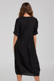 A model wearing the Guru Cotton Dress in colour Black (Black), from the back