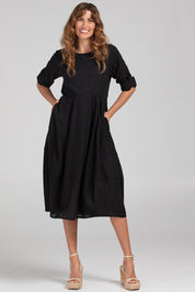 A model wearing the Guru Cotton Dress in colour Black (Black), from the front, showing the whole outfit