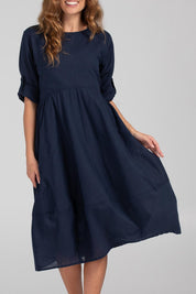 A model wearing the Guru Cotton Dress in colour Navy (Blue), from the front, cropped image