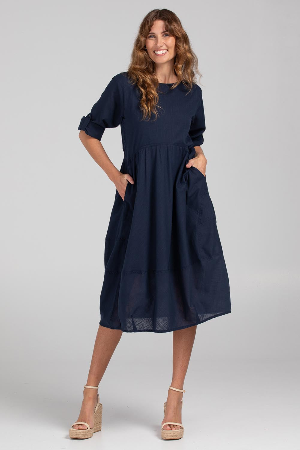 A model wearing the Guru Cotton Dress in colour Navy (Blue), from the front, showing the whole outfit