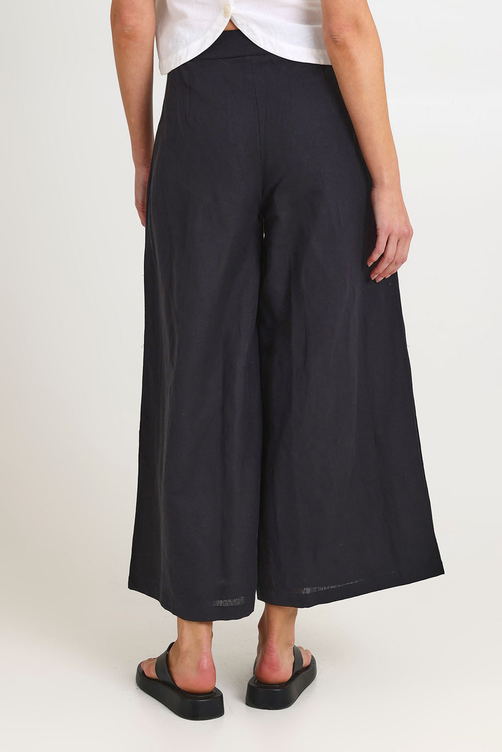 Model Madeline wearing size 10 of the Jedda Linen Cotton Pant in colour Black (Black), from the back
