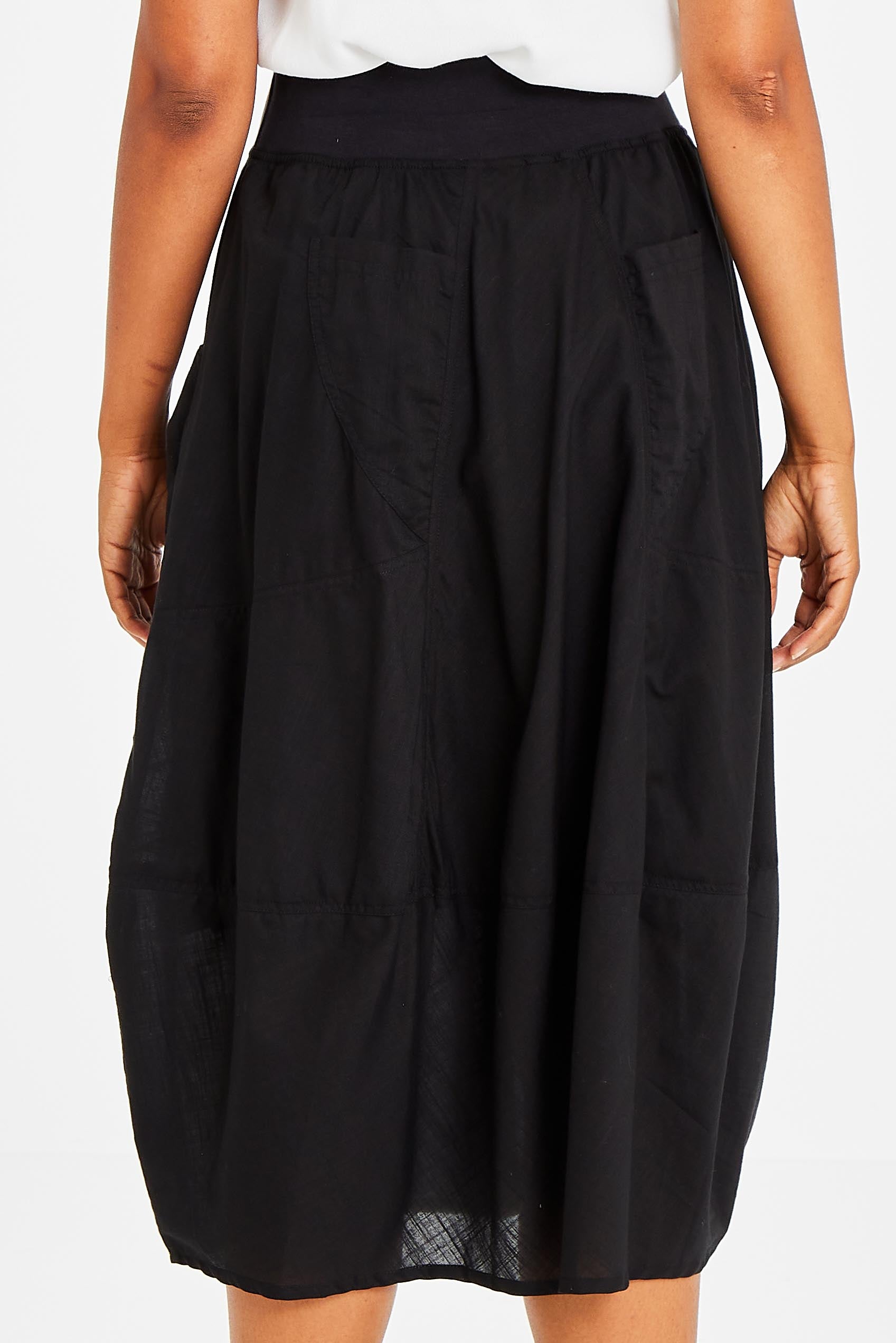 Model Olivia wearing size 10 of the Guru Skirt in colour Black (Black), from the back