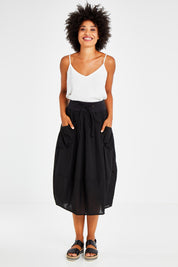 Model Olivia wearing size 10 of the Guru Skirt in colour Black (Black), from the front, showing the whole outfit