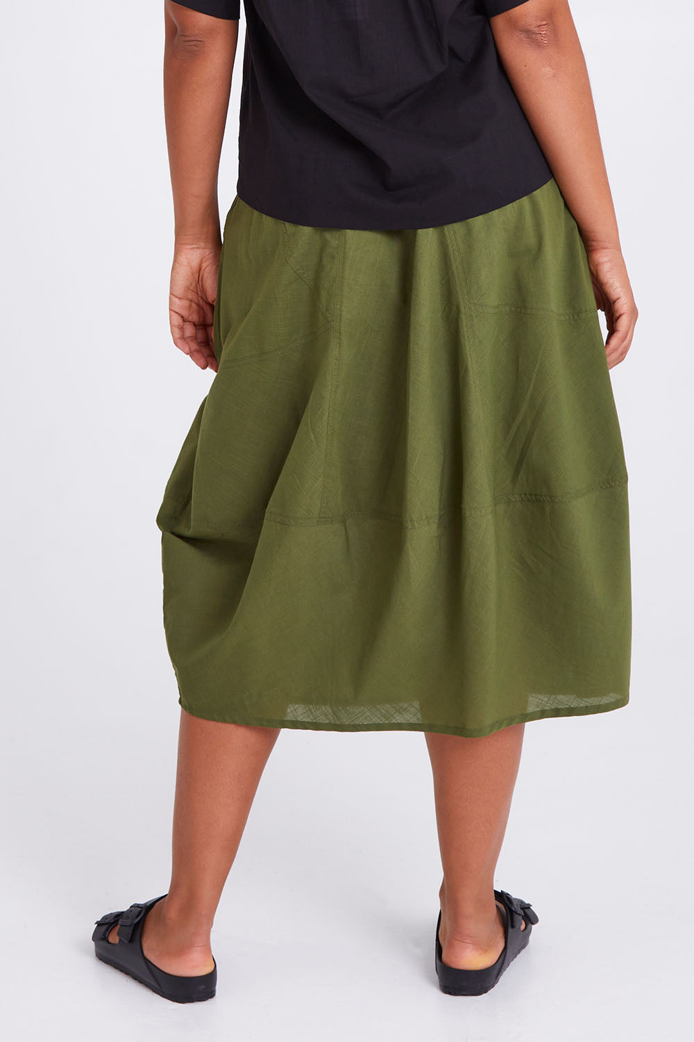 Model Olivia wearing size 10 of the Guru Skirt in colour Khaki (Green), from the back