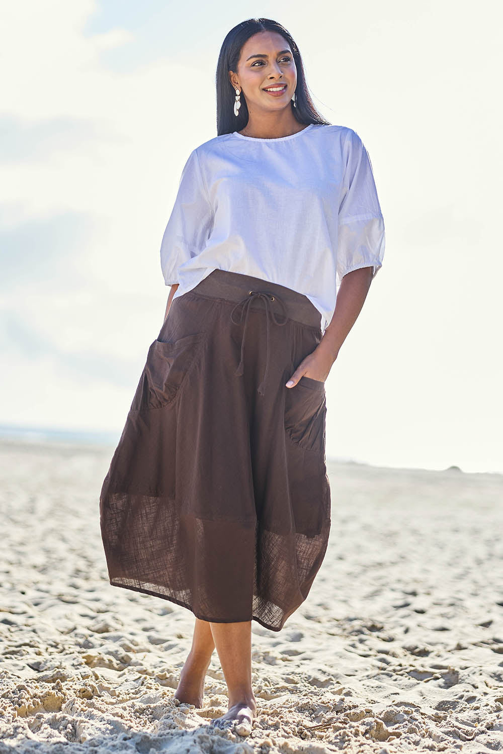Model Eshan wearing size 10 of the Guru Cotton Skirt - Coffee in colour Coffee, from the front
