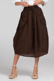 A model wearing the Guru Cotton Skirt in colour Coffee, from the front, cropped image