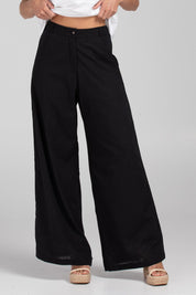 A model wearing the Luca Cotton Pant in colour Black (Black), from the front, cropped image