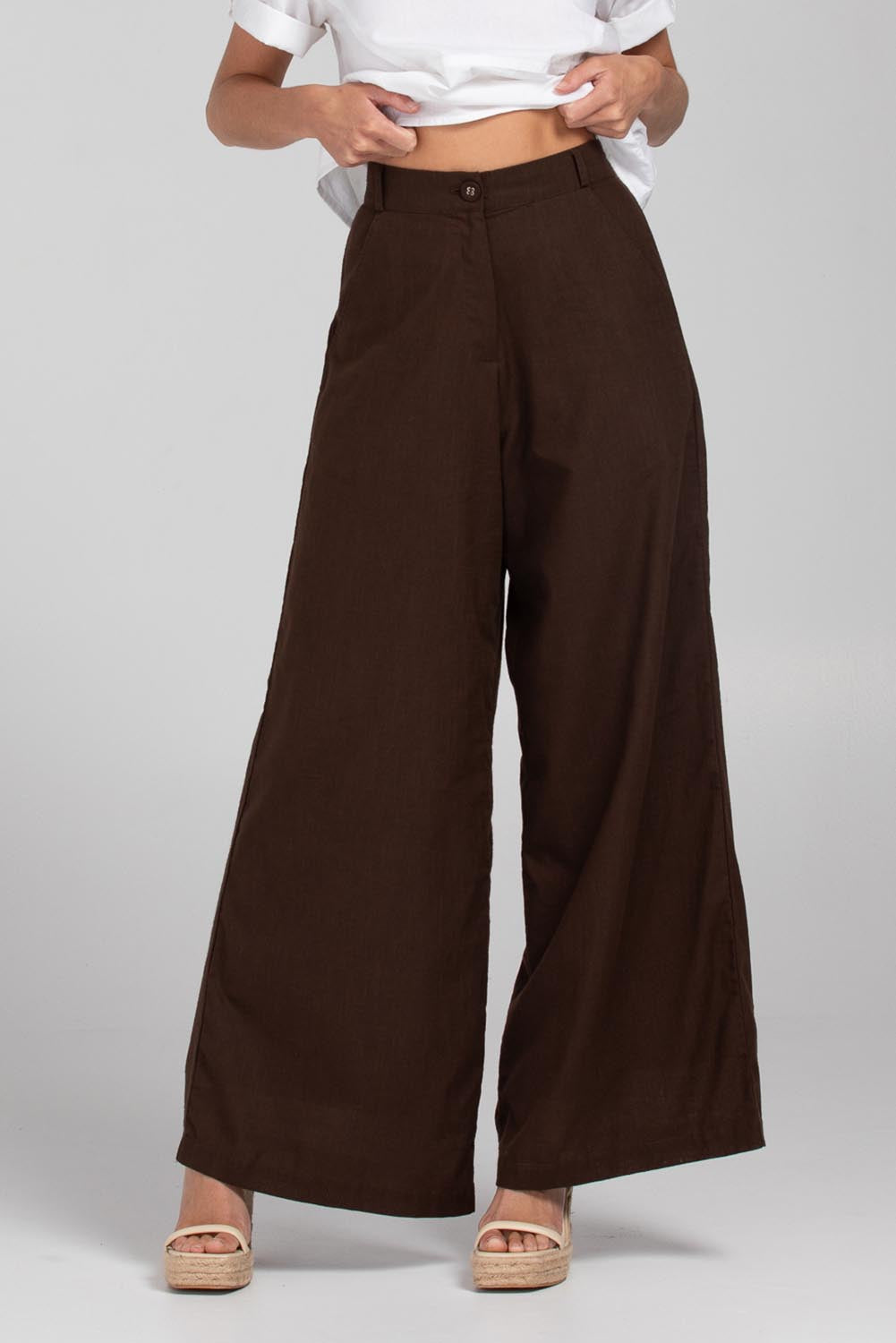 A model wearing the Luca Cotton Pant in colour Coffee, from the front, cropped image