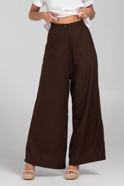 A model wearing the Luca Cotton Pant in colour Coffee, from the front, cropped image