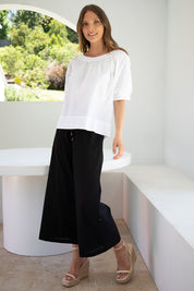 A model wearing the Ria Pant in colour Black (Black), from the front, showing the whole outfit
