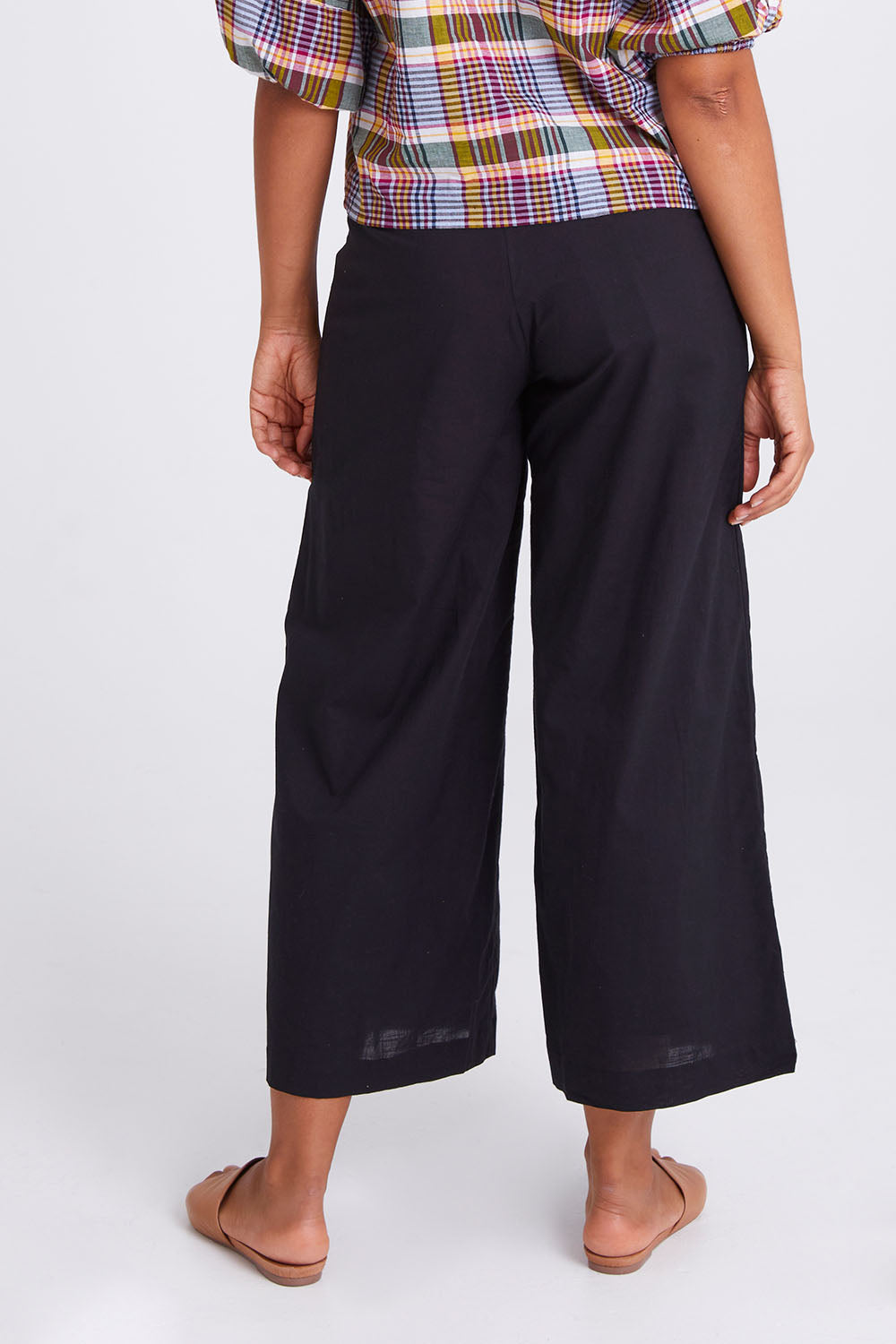 Model Olivia wearing size 10 of the Ria Pant in colour Black (Black), from the back