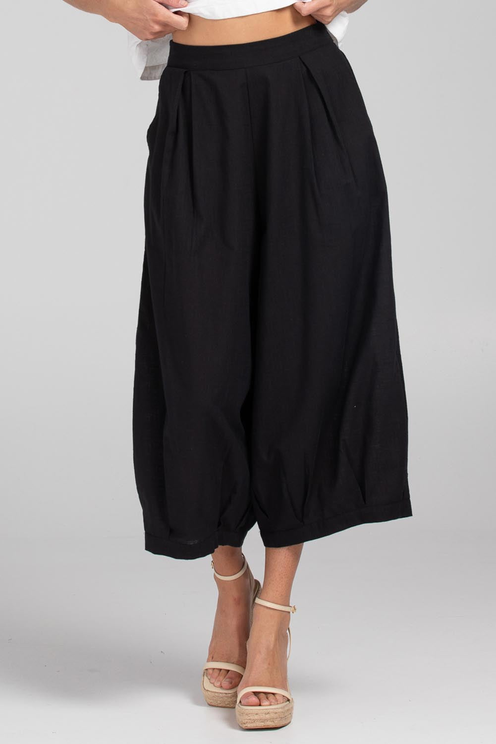 A model wearing the Zetta Cotton Pant in colour Black (Black), from the front, cropped image