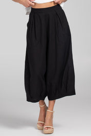 A model wearing the Zetta Cotton Pant in colour Black (Black), from the front, cropped image