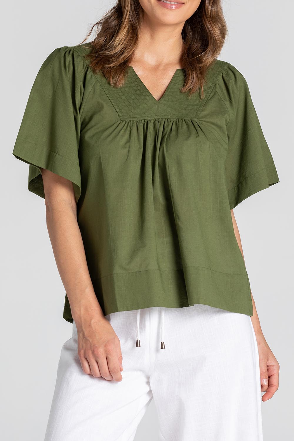 A model wearing the Freya Cotton Top in colour Khaki (Green), from the front, cropped image