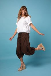 A model wearing the Guru Pant in colour Coffee, from the front, showing the whole outfit