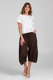 A model wearing the Guru Pant in colour Coffee, from the front, showing the whole outfit