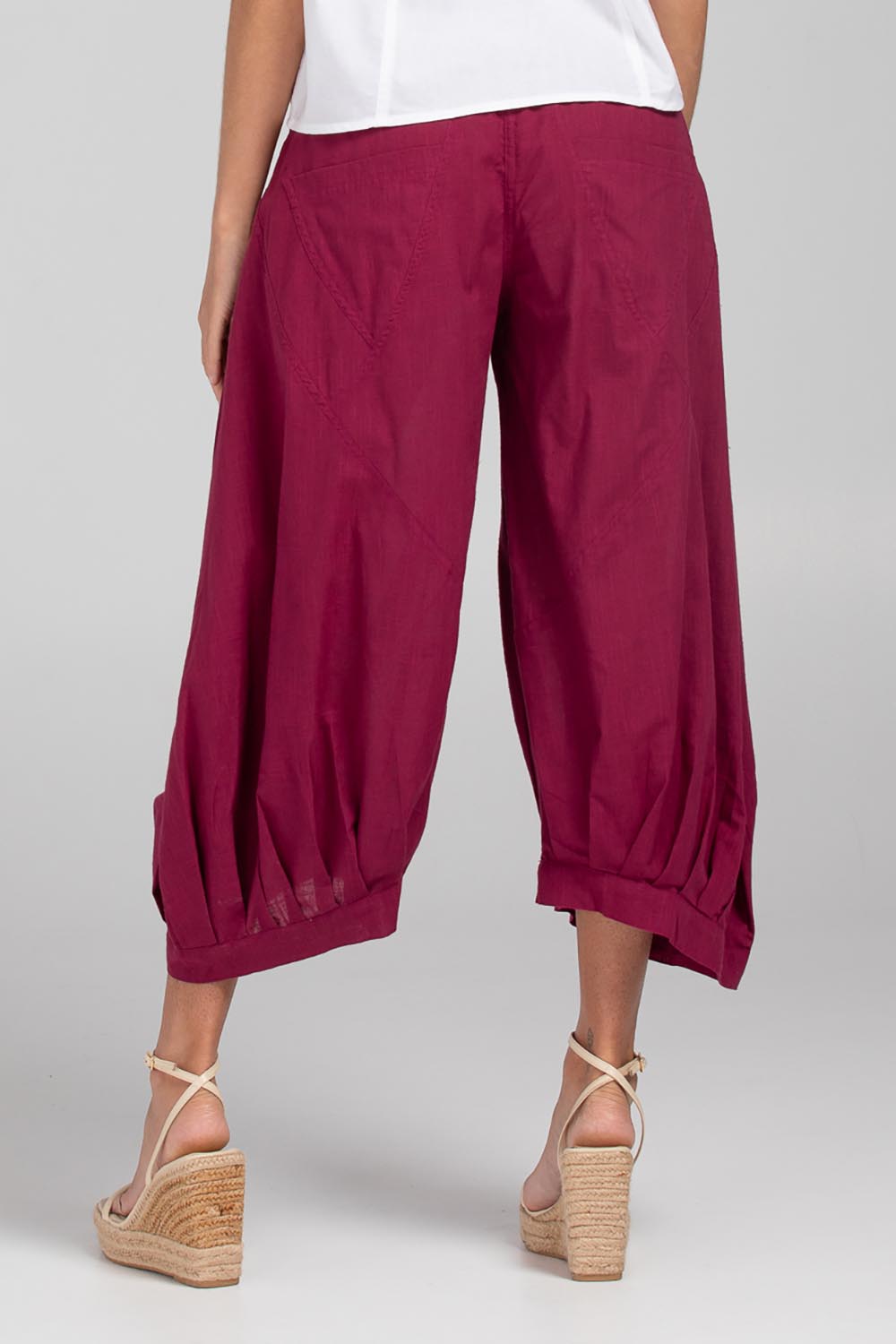 A model wearing the Guru Pant in colour Magenta (Purple), from the back