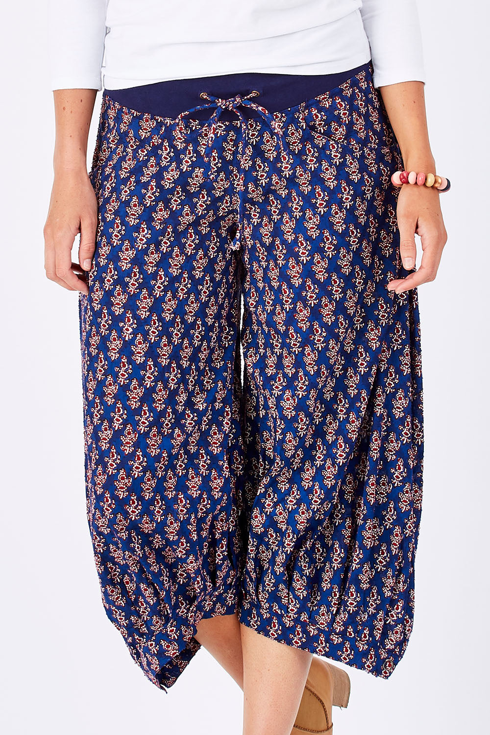 Model Perrie wearing size 10 of the Printed Guru Pants in colour Blue (Blue), from the front, cropped image
