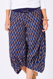 Model Perrie wearing size 10 of the Printed Guru Pants in colour Blue (Blue), from the front, cropped image