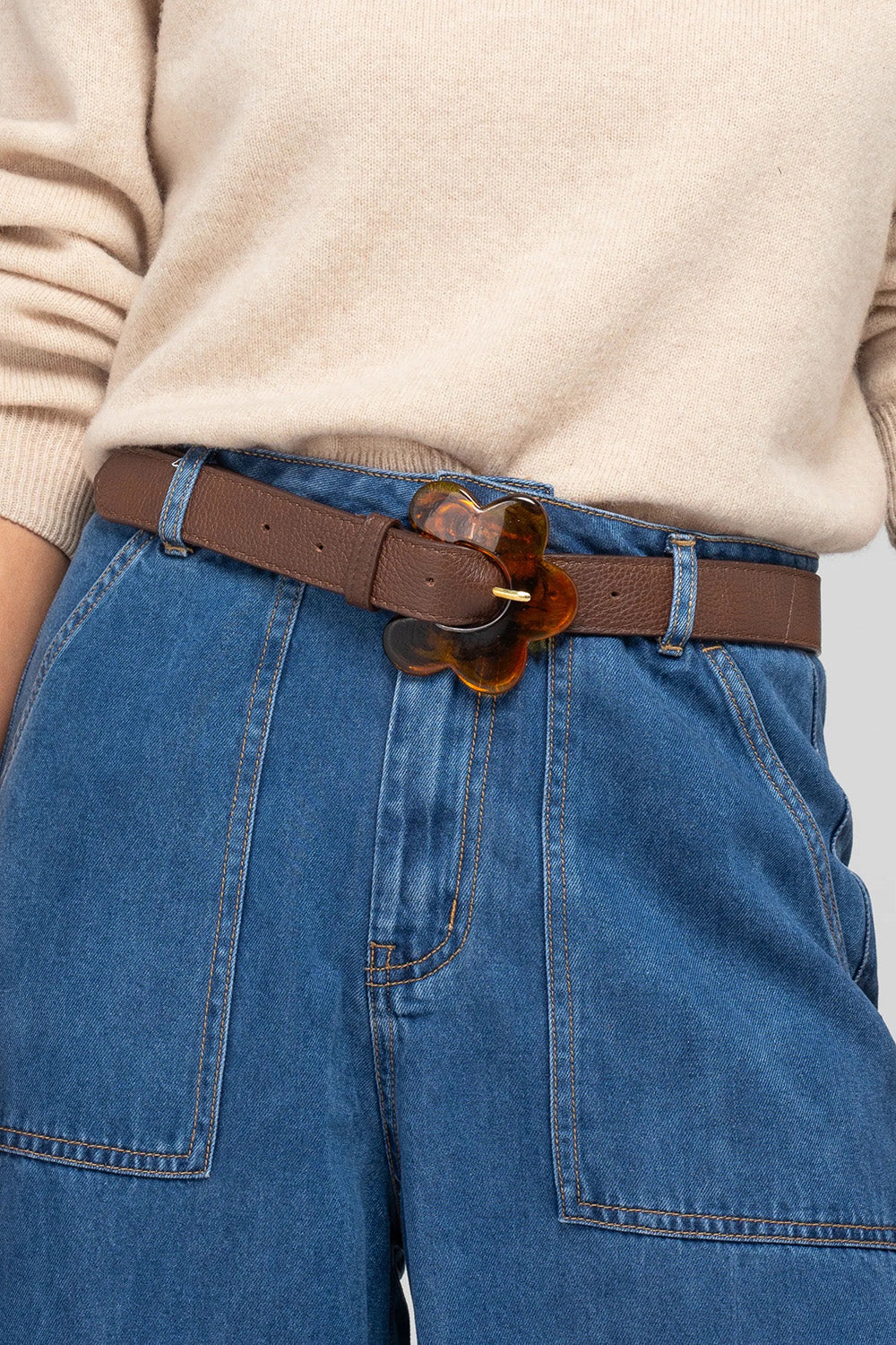 A model wearing the Flower Leather Belt in colour Chocolate, from the front, showing the whole outfit