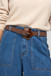 A model wearing the Flower Leather Belt in colour Chocolate, from the front, showing the whole outfit