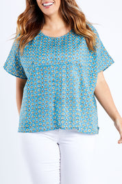 Model Laura wearing size 14 of the Alora Top in colour Bananaflow (Blue), from the front, cropped image