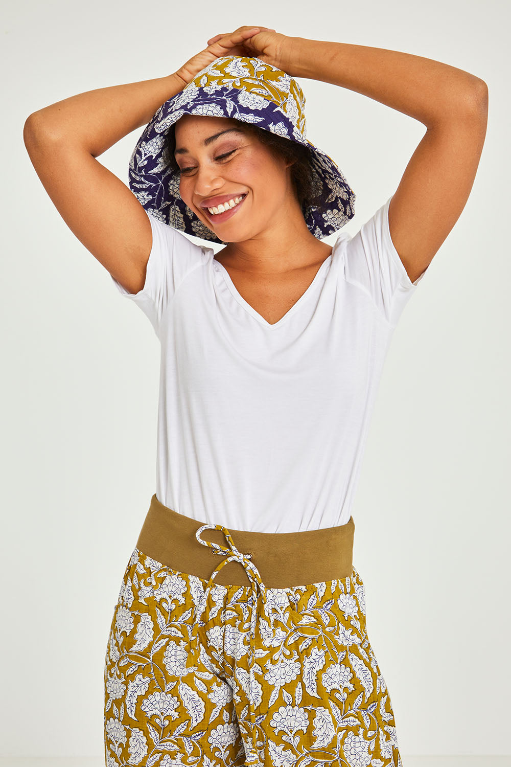Model Olivia wearing the Reversible Wide Brim Bucket Hat in colour Sapphire (Blue), from the front, cropped image