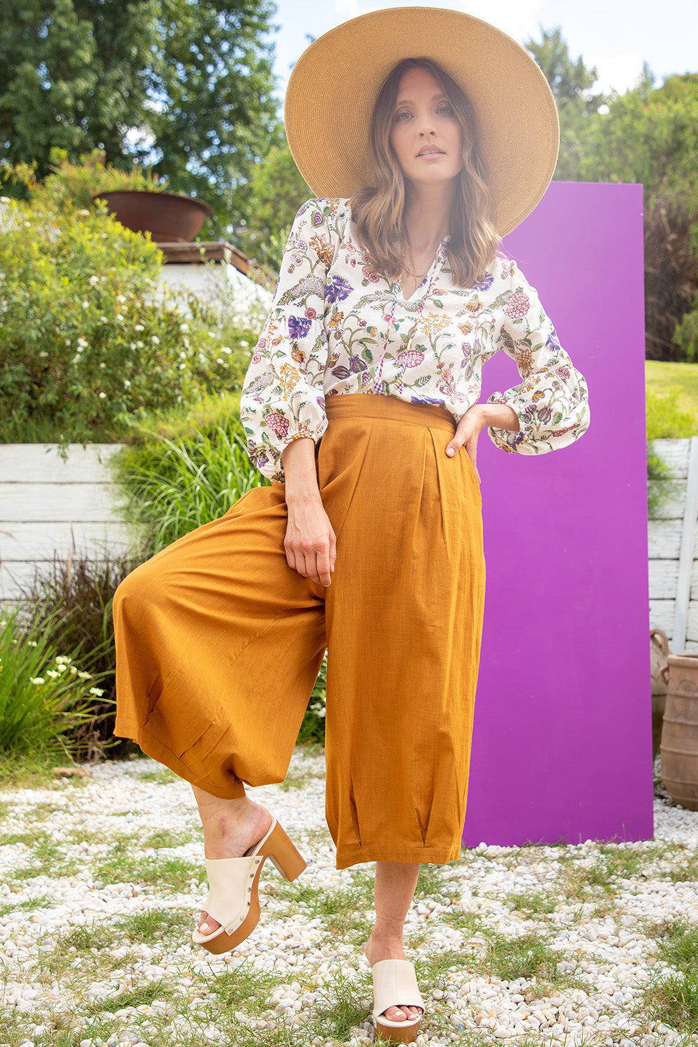 A model wearing the Zetta Pant in colour Mustard, from the front, showing the whole outfit