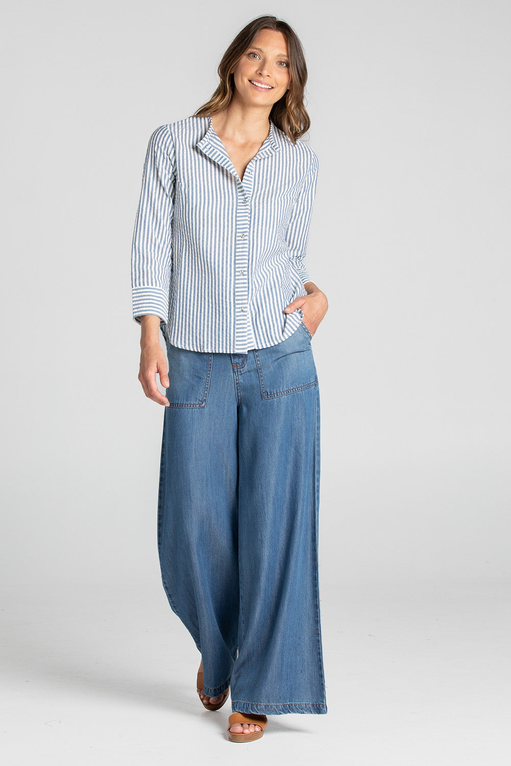 A model wearing the Hazel Shirt in colour Hazelstrip (Blue), from the front, showing the whole outfit