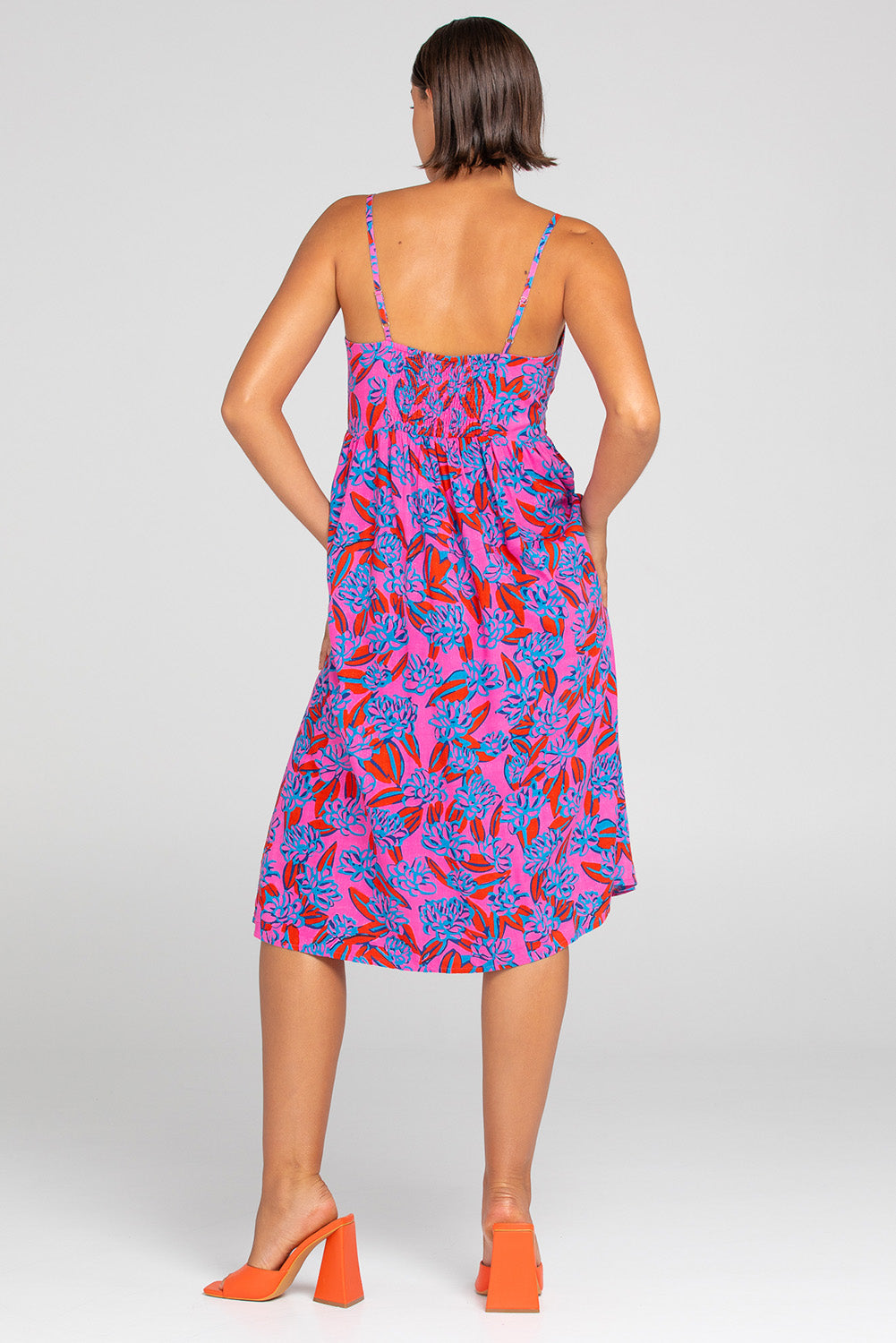 A model wearing the Ailana Dress in colour Ray (Pink), from the back