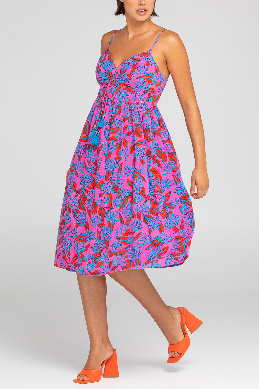 A model wearing the Ailana Dress in colour Ray (Pink), from the front, cropped image