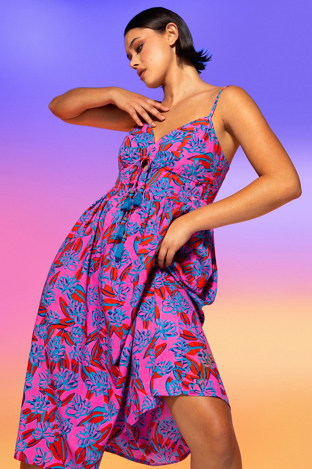 A model wearing the Ailana Dress in colour Ray (Pink), from the front, showing the whole outfit