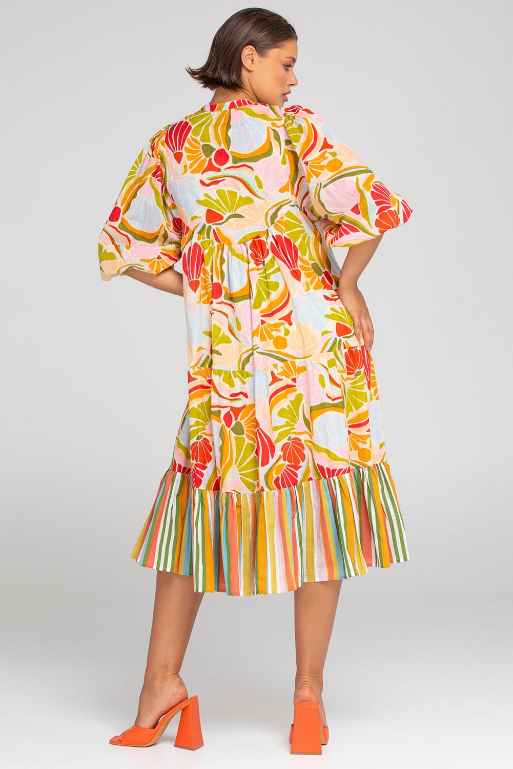 A model wearing the Mabel Cotton Dress in colour Colada (Green), from the back