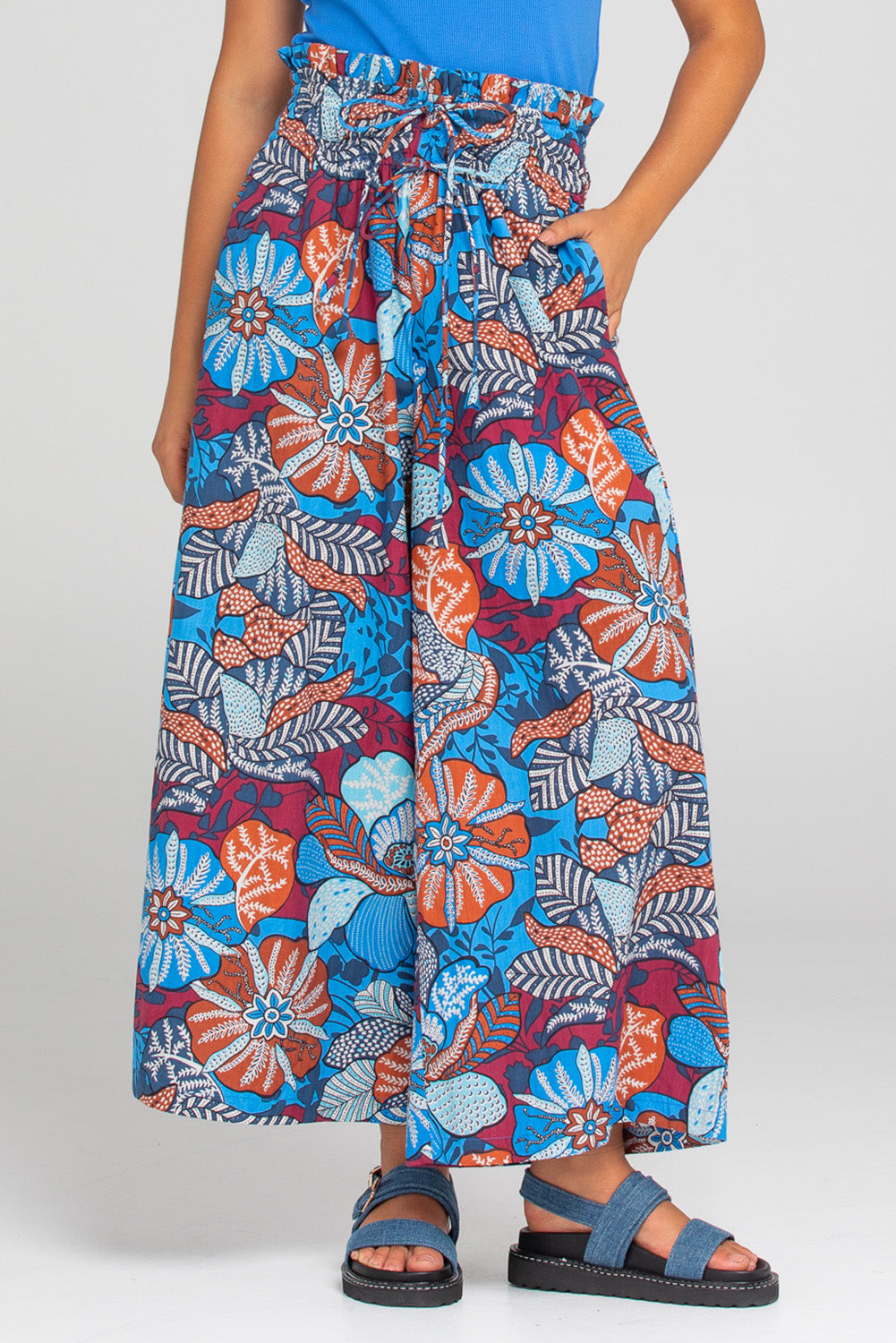 A model wearing the Etta Cotton Pant in colour Diah (Blue), from the front, cropped image