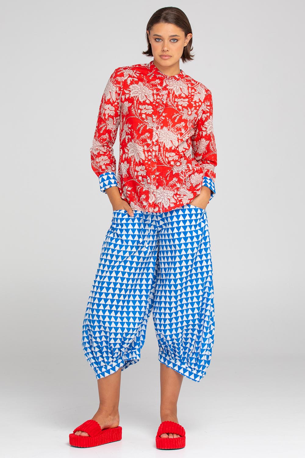 A model wearing the Cove Cotton Shirt in colour Farrah (Red), from the front, showing the whole outfit